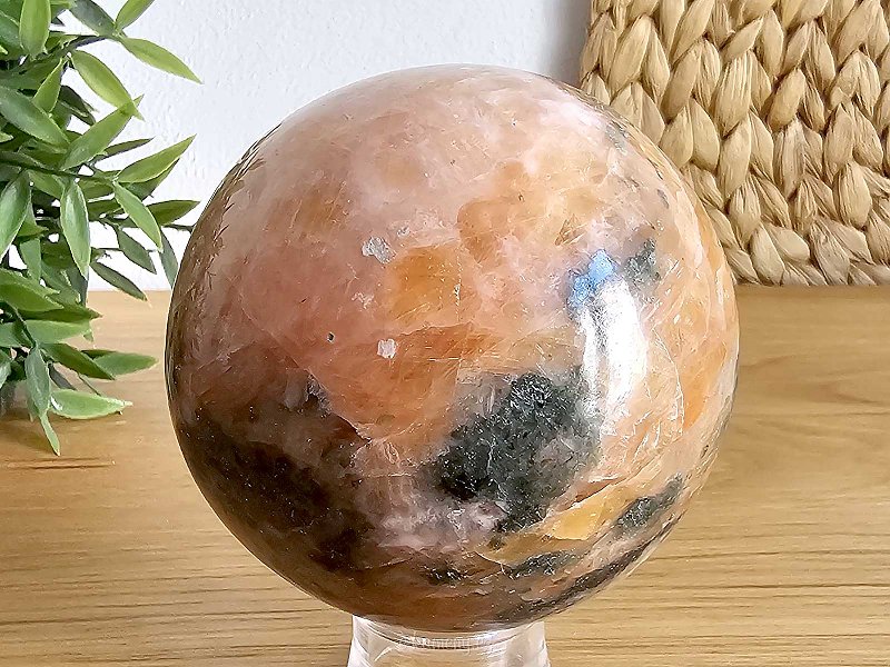 Orange calcite stone in the shape of a ball with a diameter of 8 cm