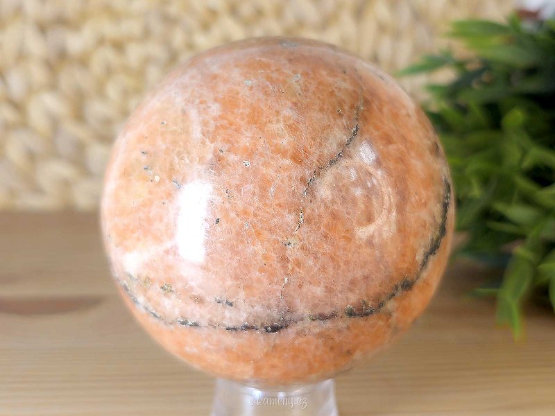 Orange calcite stone in the shape of a ball with a diameter of 8.1 cm