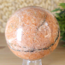 Orange calcite stone in the shape of a ball with a diameter of 8.1 cm