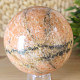 Orange calcite stone in the shape of a ball with a diameter of 8.1 cm