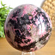 Stone in the shape of a ball of rhodonite with a diameter of 9.0 cm