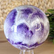 A chevron amethyst stone in the shape of a sphere with a diameter of 9.5 cm